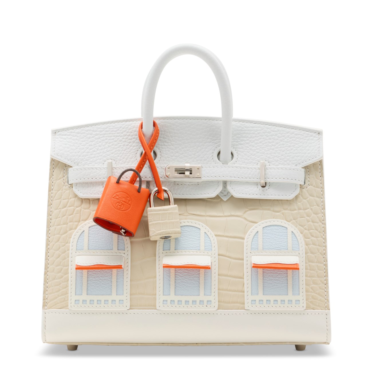 A designer handbag with white handles and a building window motif on the front.
