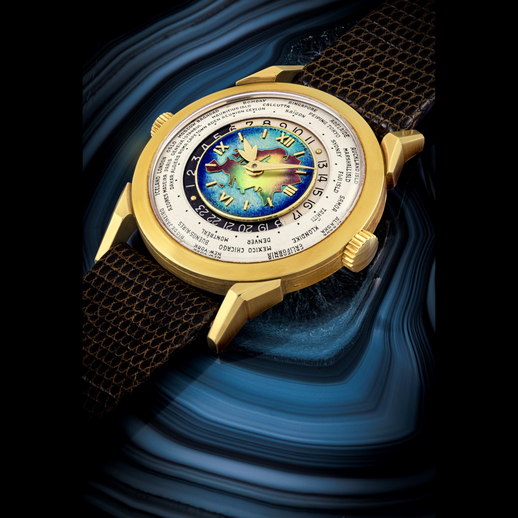 A luxurious, gold wristwatch with a zodiac-themed, colorful face, displayed on a dark blue, wavy backdrop.