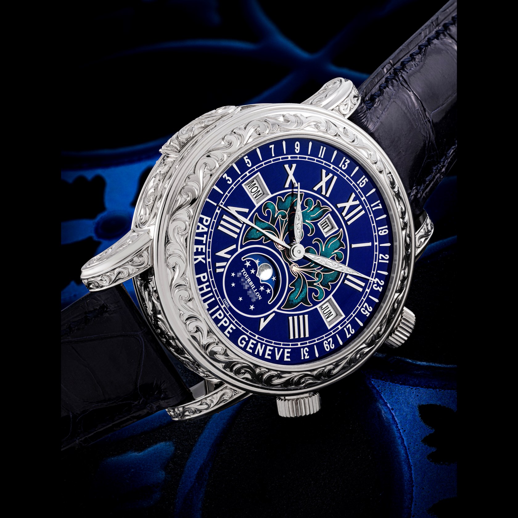 An intricately carved silver watch featuring a blue face with Roman numerals and a moon phase indicator.