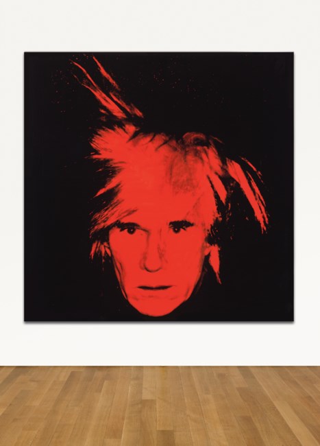 A black canvas features bold red brushstrokes radiating from a central area, displayed in a gallery.