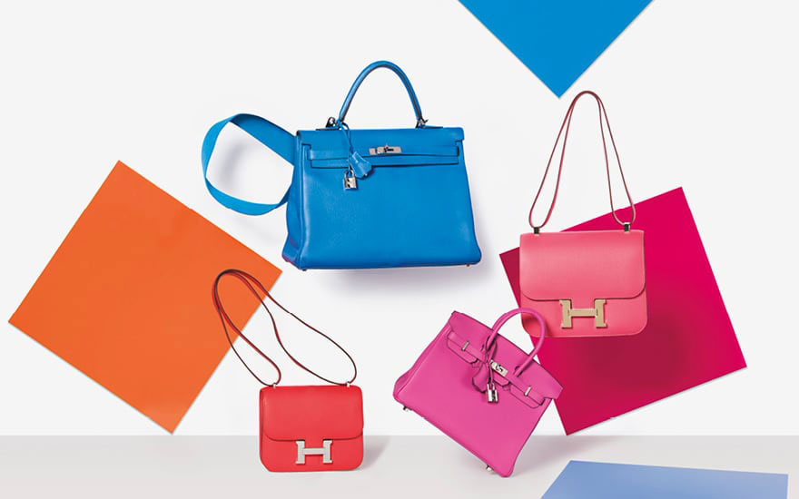 Colorful designer bags displayed against a backdrop with vibrant geometric shapes.