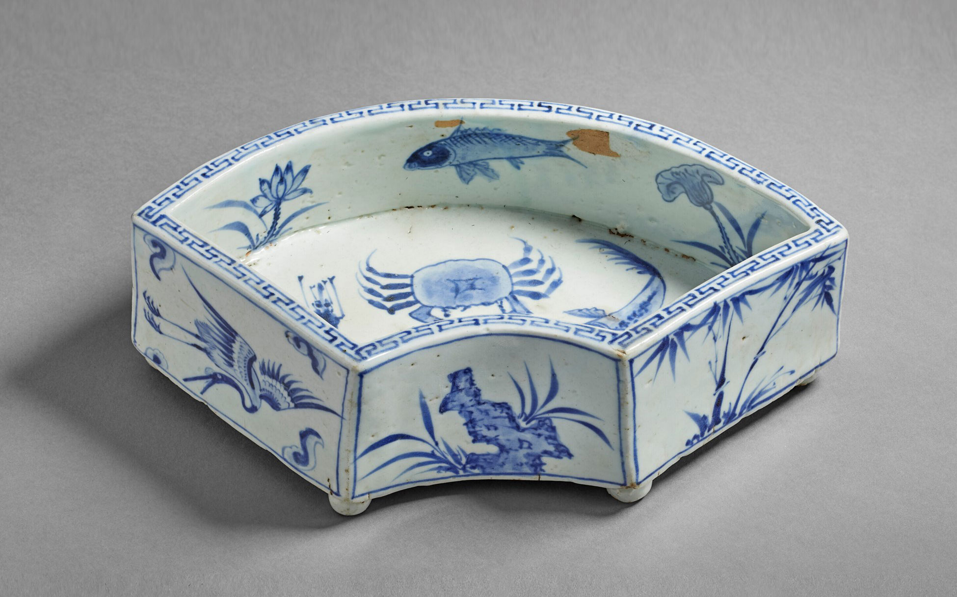 Octagonal blue and white porcelain dish decorated with fish and floral motifs.