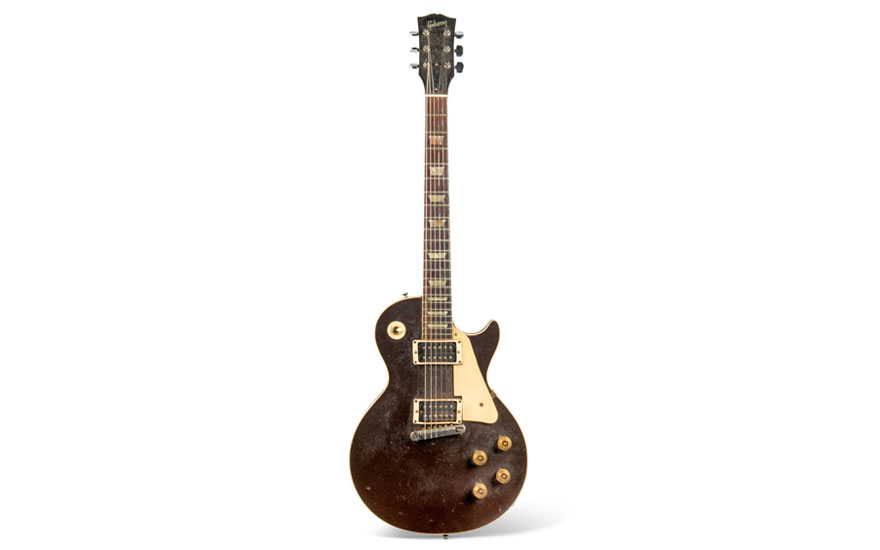 A vintage electric guitar with a worn brown finish and two pickups, isolated on a white background.