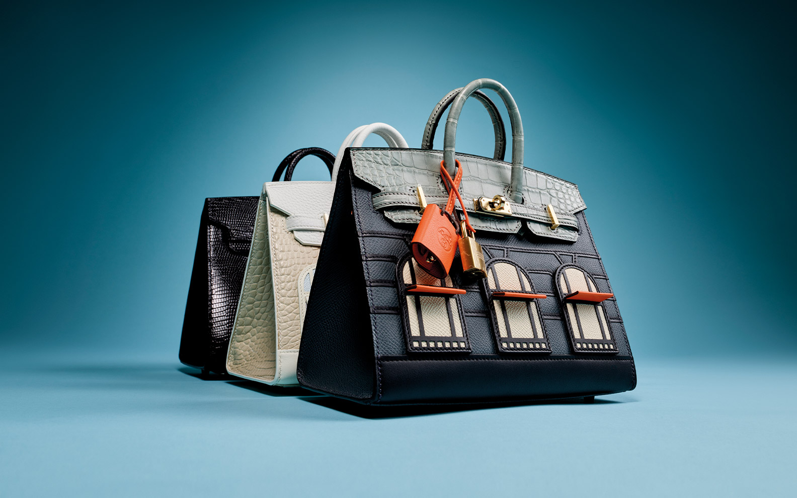 A collection of elegant, textured handbags in various shapes and muted colors displayed against a blue background.