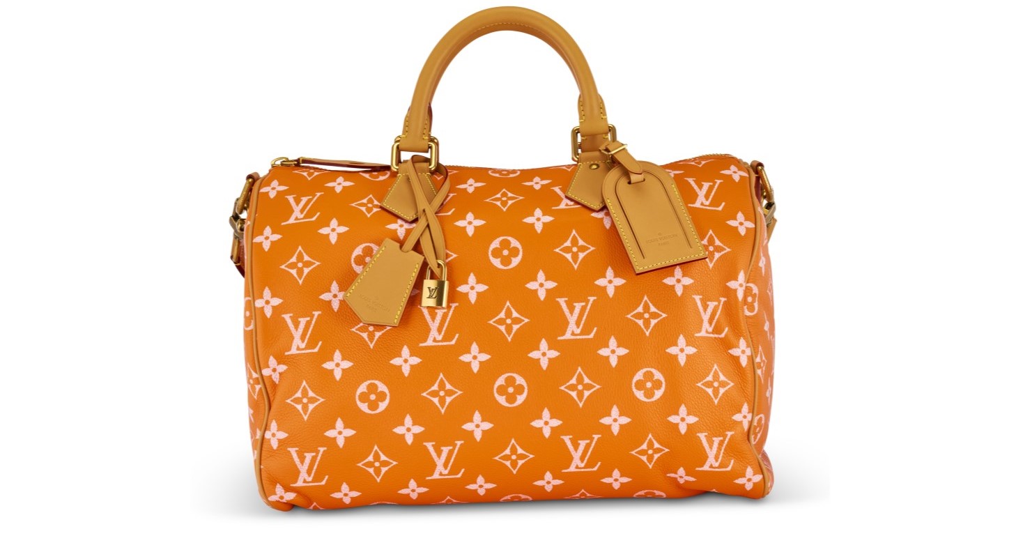 An orange Louis Vuitton handbag with white monogram pattern and tan leather handles.