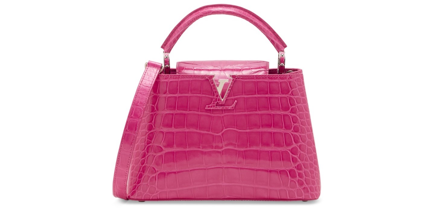 A pink crocodile-embossed handbag with a top handle and shoulder strap.