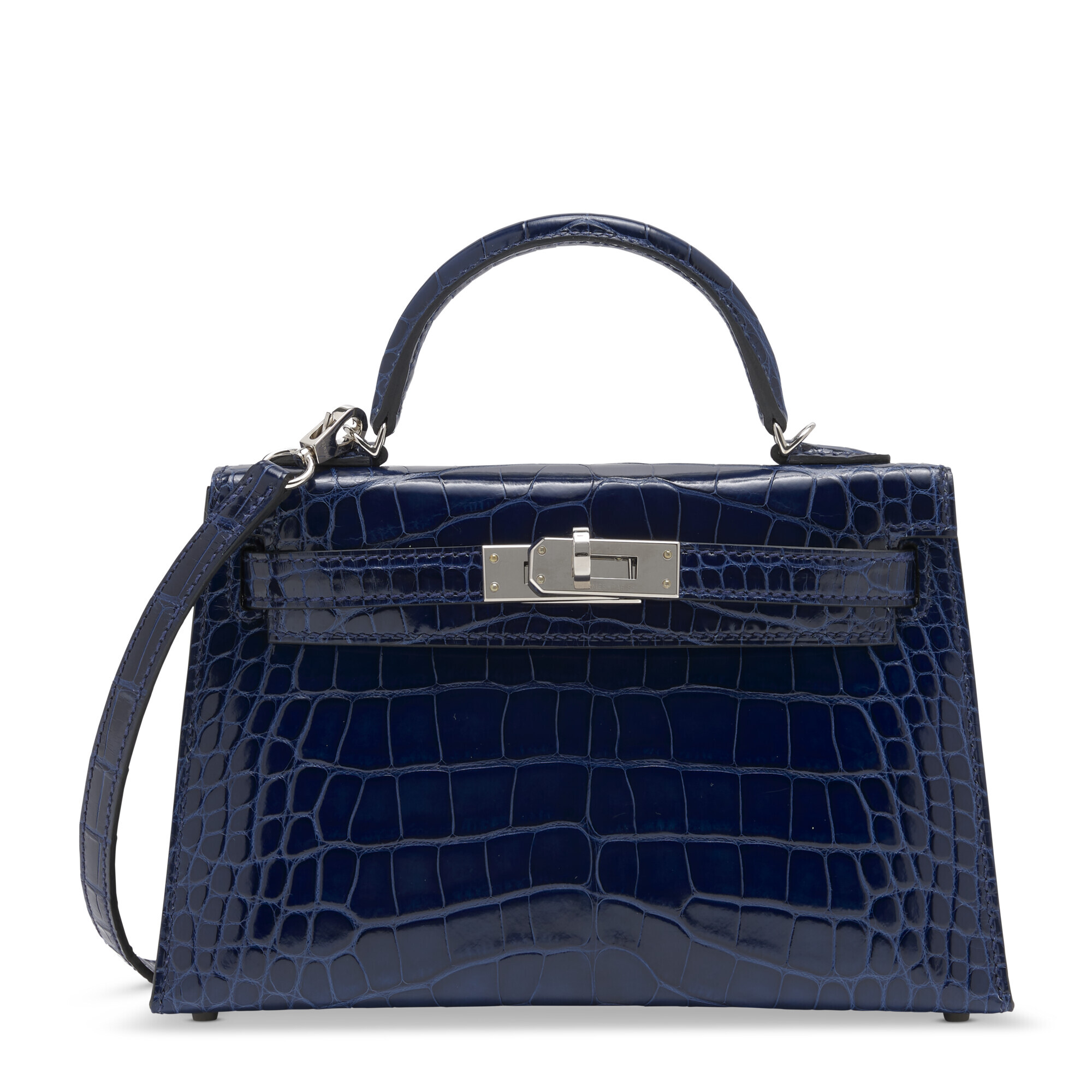 A navy blue crocodile leather handbag with a top handle and silver hardware.
