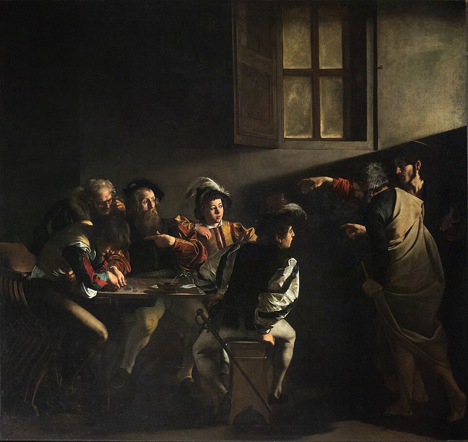 A group of men sit at a table while two figures point dramatically from the right, illuminated by light.
