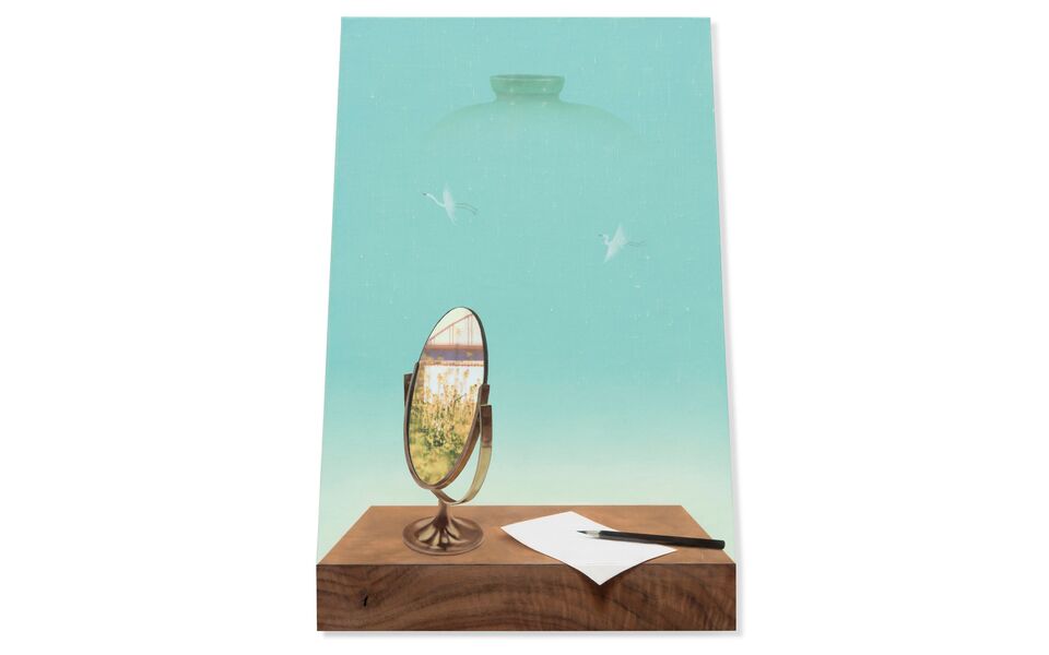 A mirror, paper, and pen sit on a wooden surface against a surreal blue-green background.