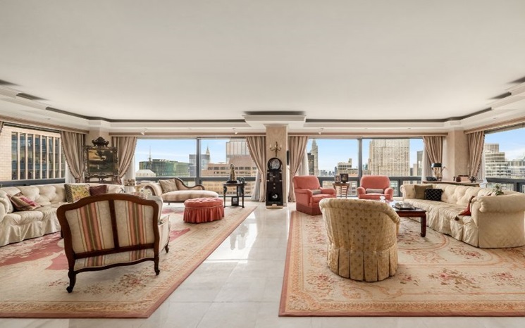 A luxurious living room with large windows, elegant furniture, and a city skyline view.