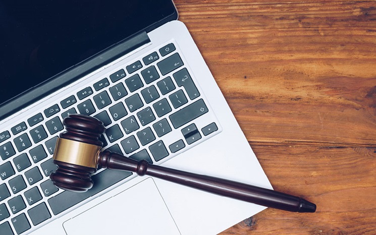 auctioneer gavel lying on top of a laptop