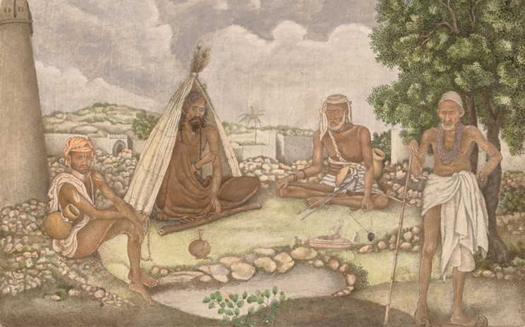 Four people in traditional attire are gathered outdoors near a small tent and trees.