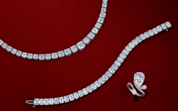 Diamond necklace, bracelet, and ring displayed on a red background.