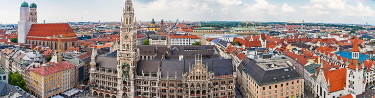 Panoramic aerial view of Munich cityscape featuring prominent Gothic Revival architecture of the New Town Hall.