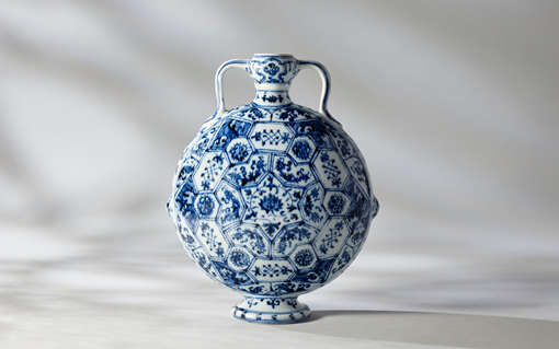 A blue and white porcelain flask with intricate floral patterns and two handles.