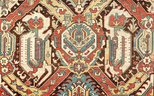 The image shows a colorful, intricately patterned traditional carpet with geometric designs.