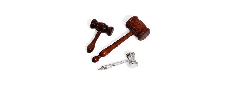 Three gavels are displayed, two wooden and one metallic, arranged on a white background.