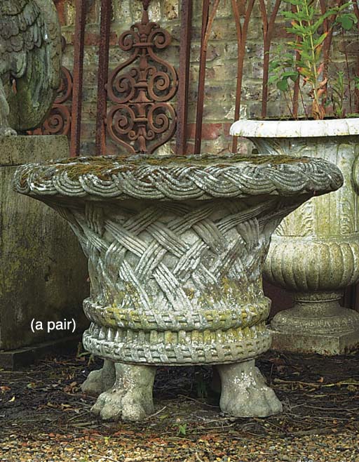 A PAIR OF LARGE COMPOSITE STONE BASKET URNS