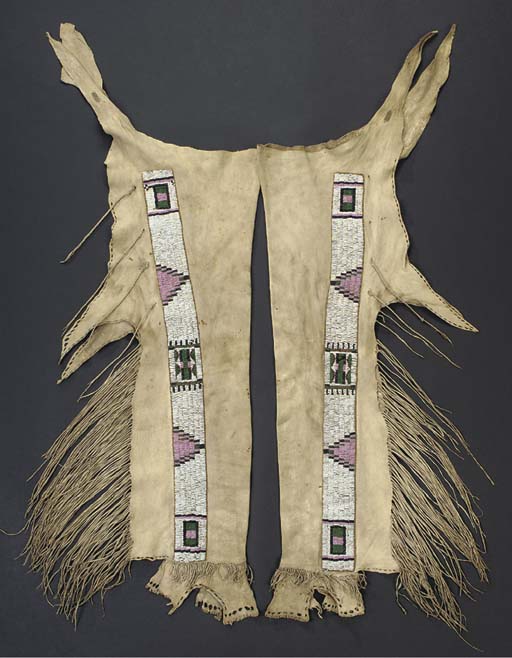 A PAIR OF JICARILLA APACHE BEADED AND FRINGED HIDE LEGGINGS