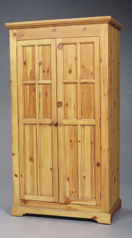 A PANELLED AND STAINED KNOTTY PINE ARMOIRE