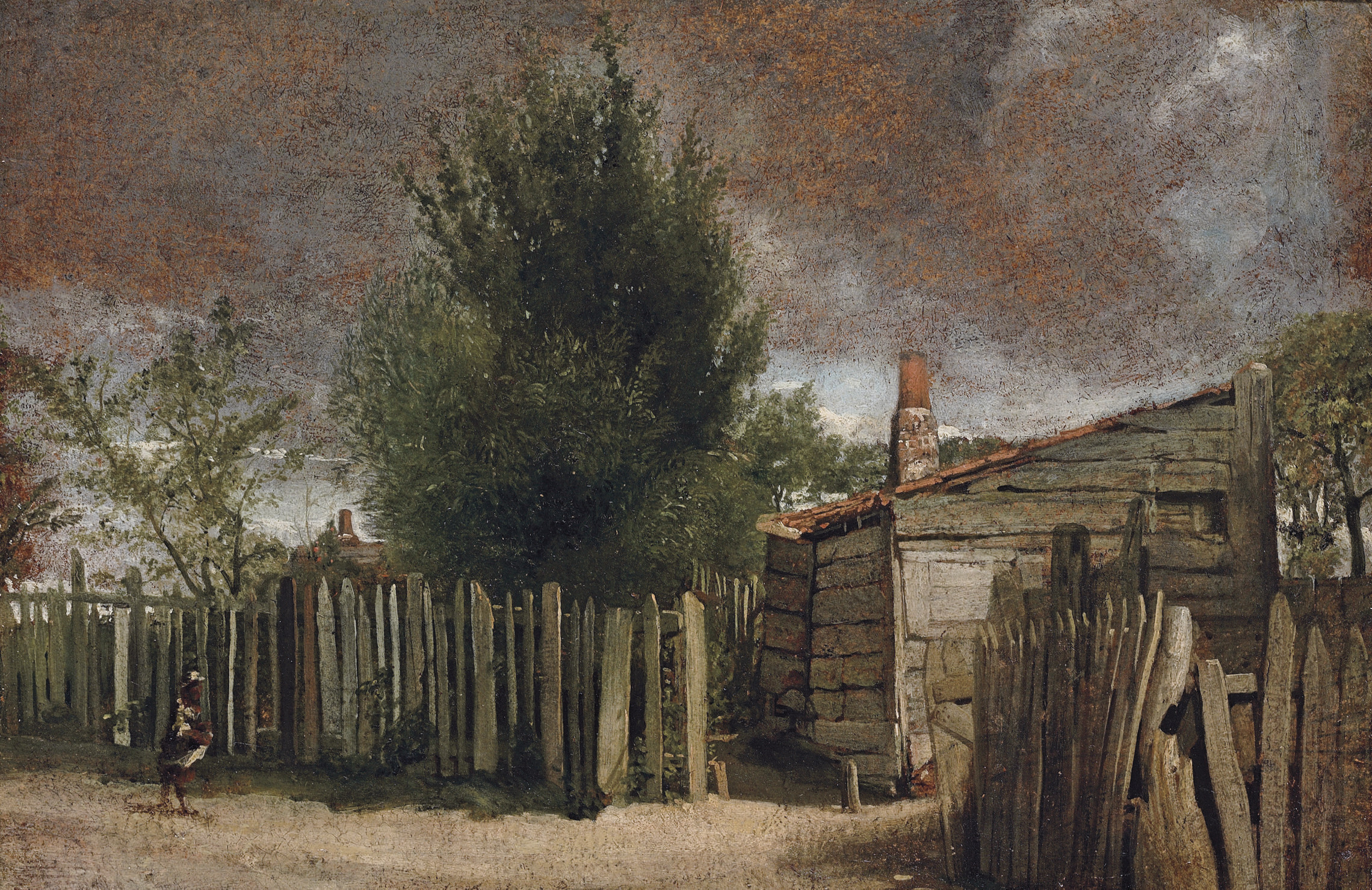 A wooden building with a figure bya fence 
