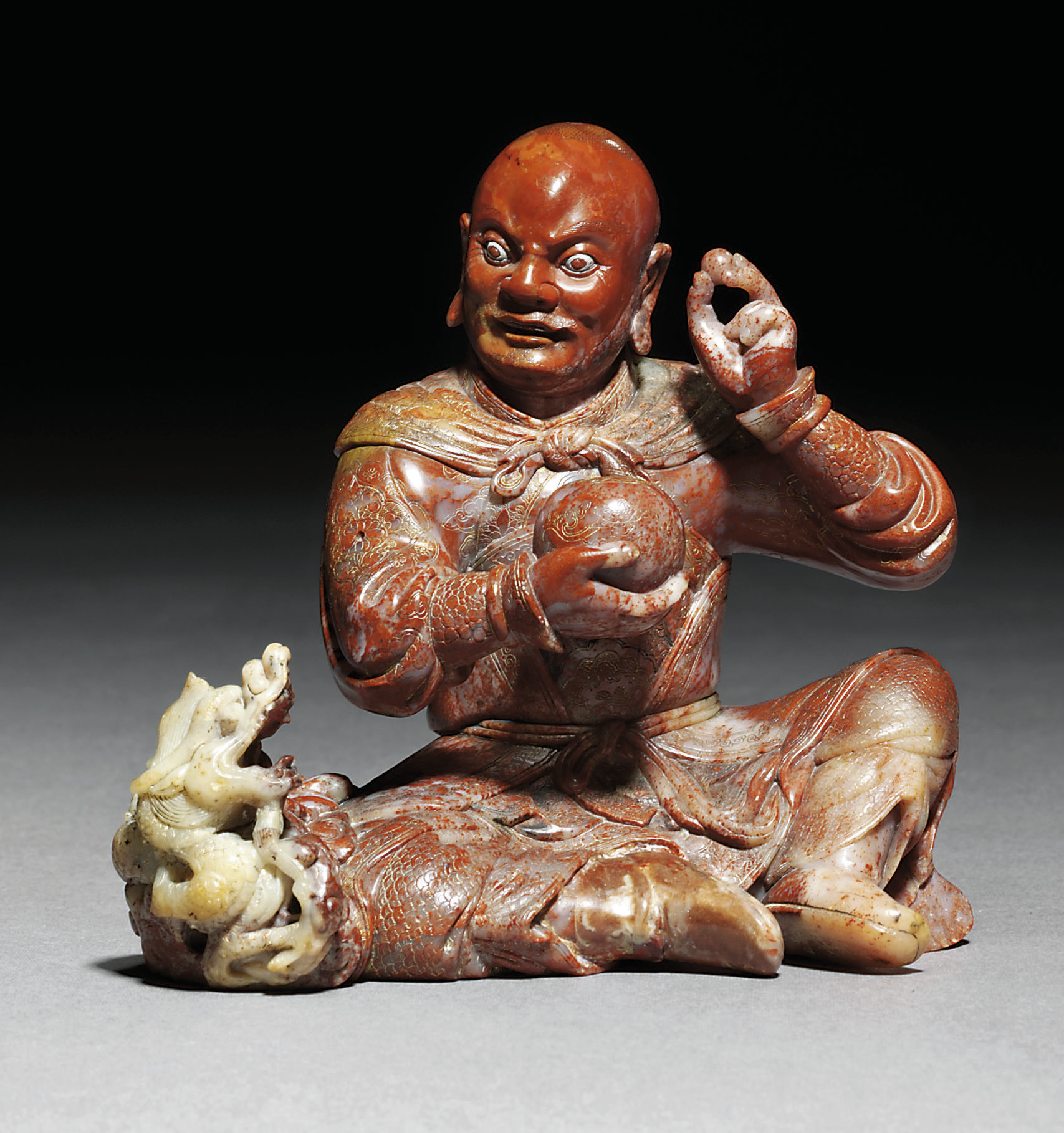 A SOAPSTONE FIGURE OF A SEATED LUOHAN