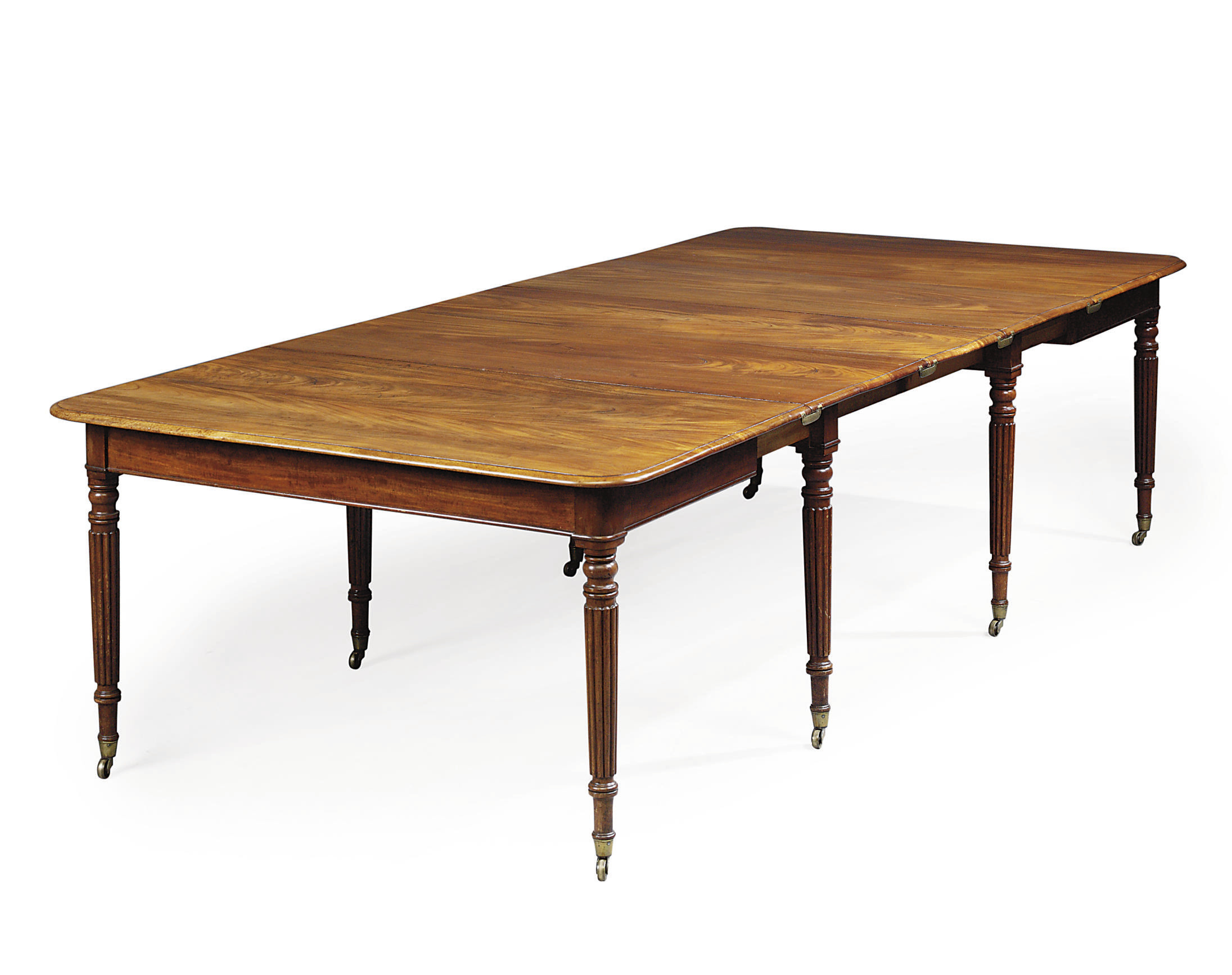 A REGENCY MAHOGANY EXTENDING DININGTABLE , IN THE MANNER OF GILLOWS