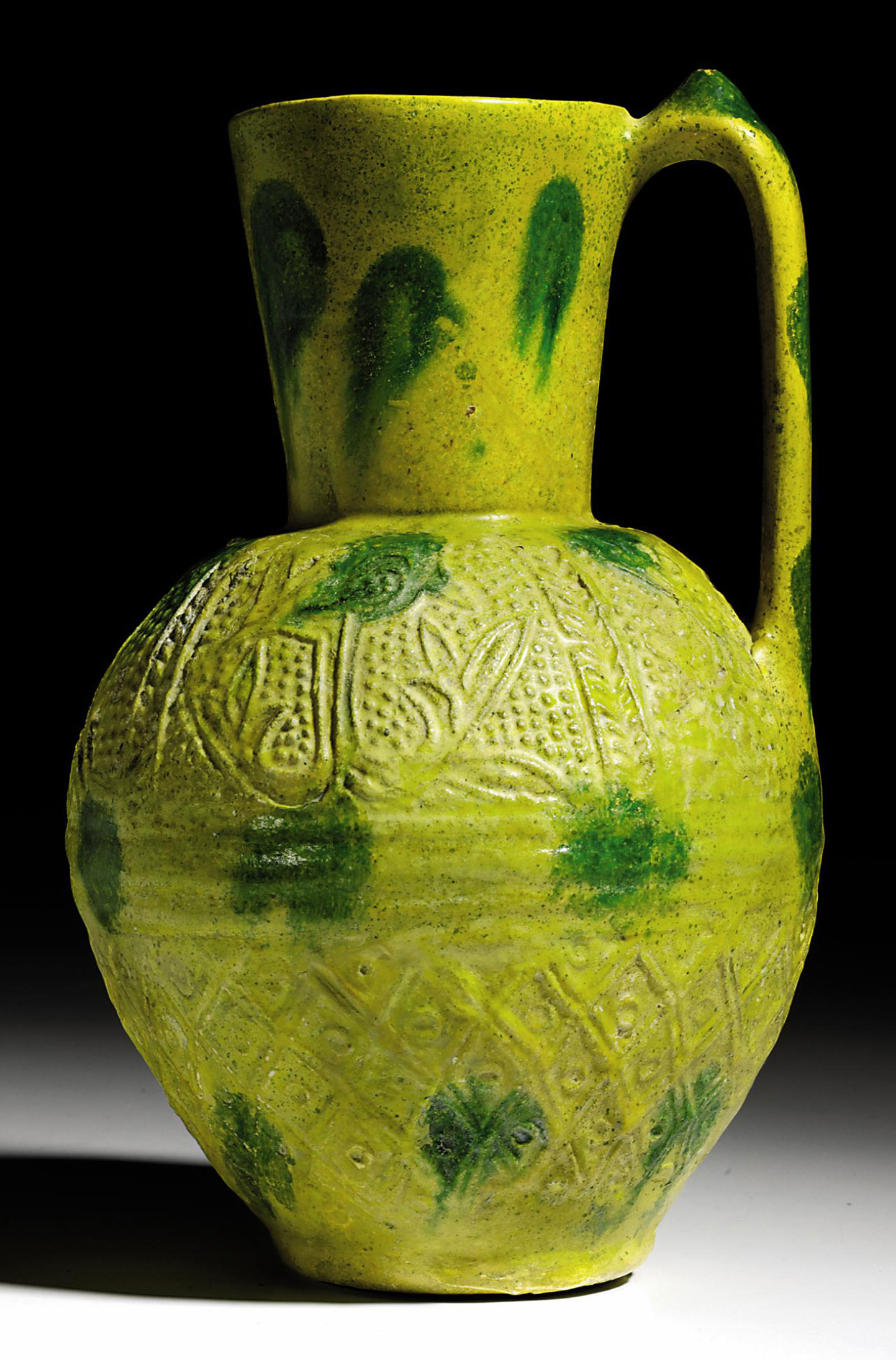 AN UMAYYAD GREEN SPLASHED YELLOW GLAZED POTTERY JUG , EASTERN MEDITERRANEAN, POSSIBLY EGYPT, 8TH