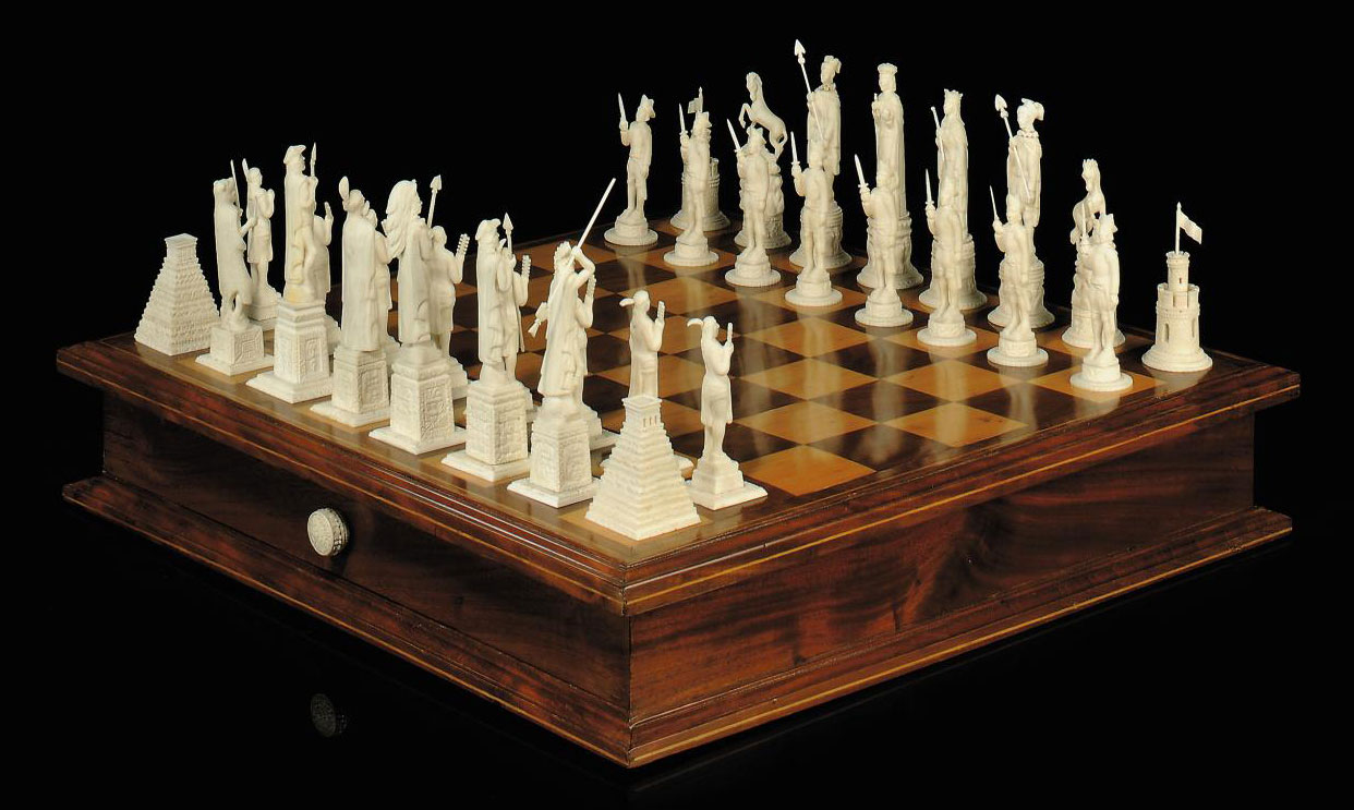 A CARVED BONE FIGURAL CHESS SET AND FRUITWOOD INLAID MAHOGANY BOARD