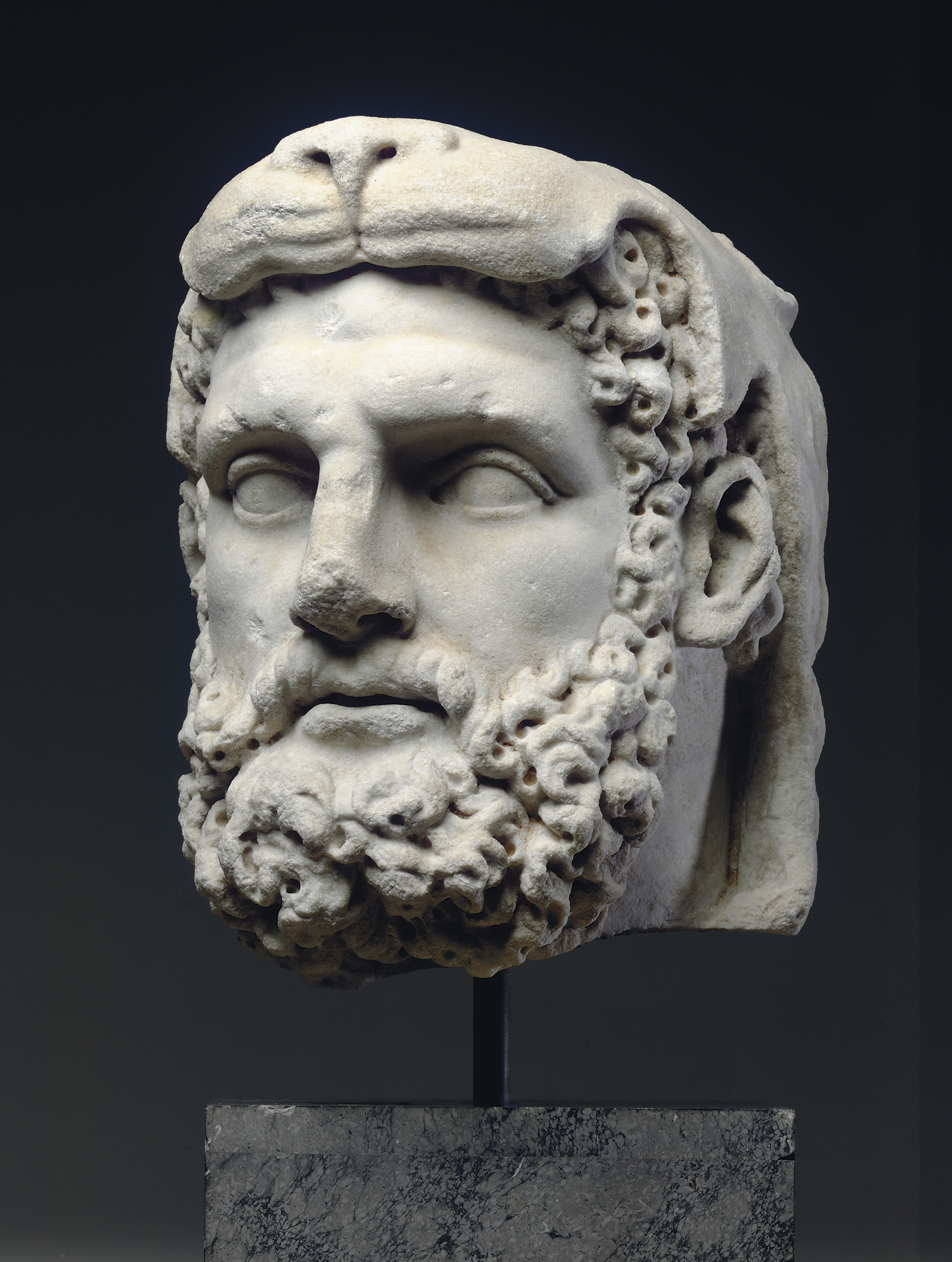 A ROMAN OVERLIFESIZED MARBLE HEAD OF HERCULES , FLAVIAN PERIOD, CIRCA