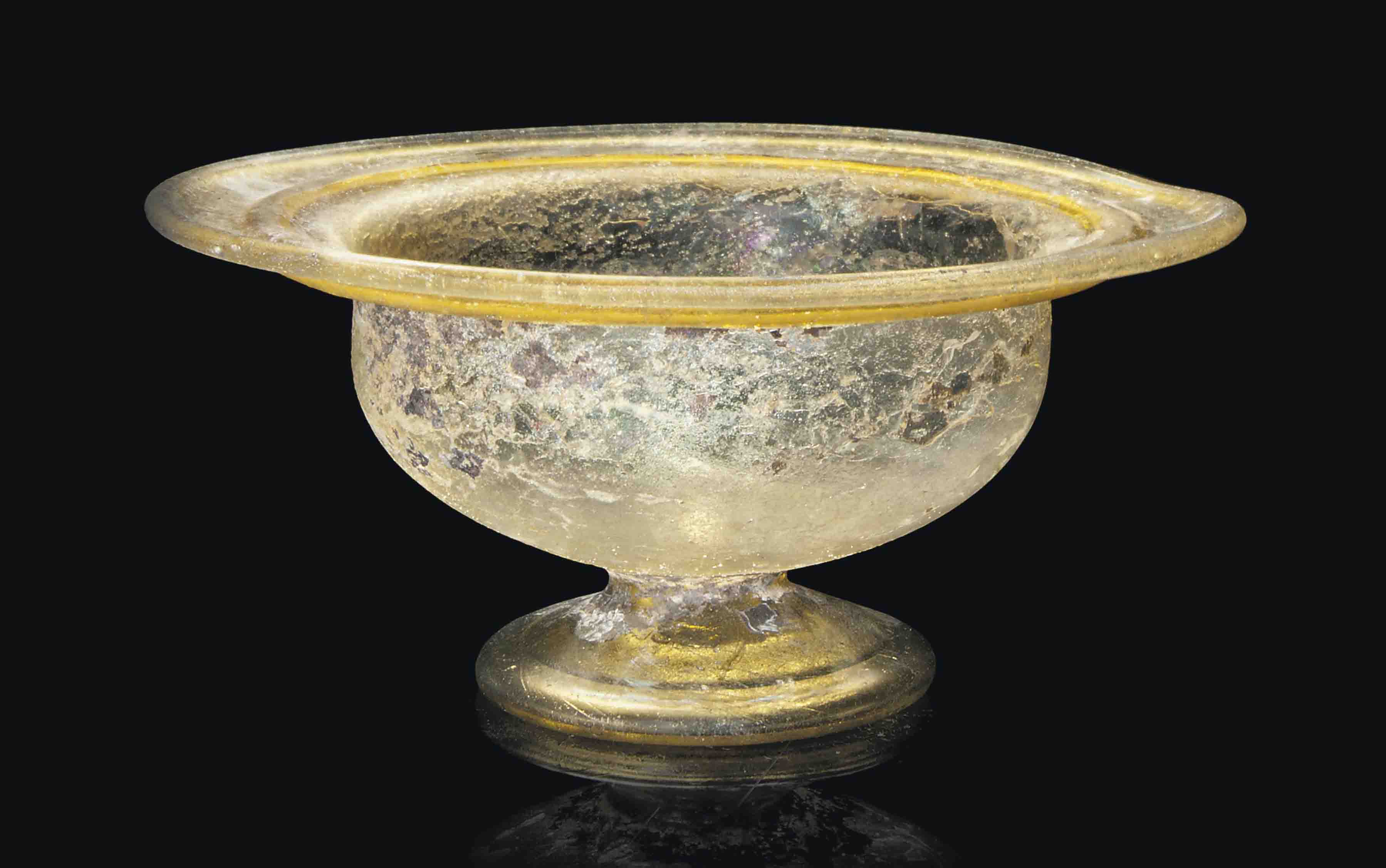 A LATE ROMAN GREEN GLASS FOOTED BOWL , CIRCA LATE 2NDEARLY 3RD CENTURY
