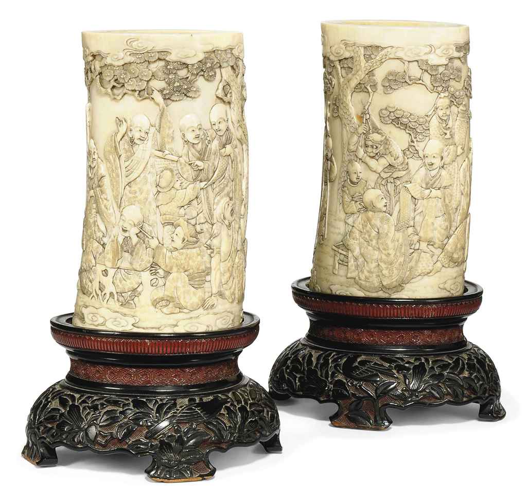 A PAIR OF JAPANESE CARVED IVORY TUSK SECTIONS WITH LACQUERED WOODSTANDS
