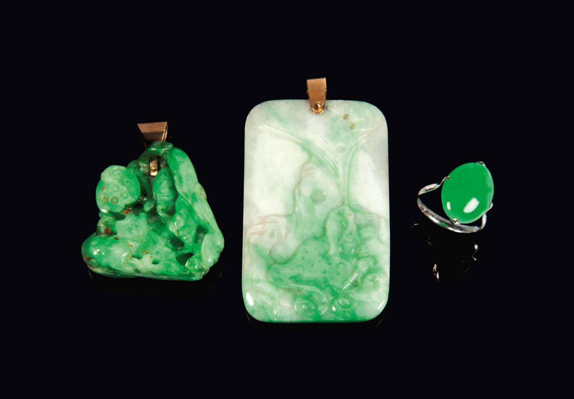 TWO CHINESE APPLE GREEN JADEITE PENDANTS AND ONE JADEITE PLAQUE MOUNTED