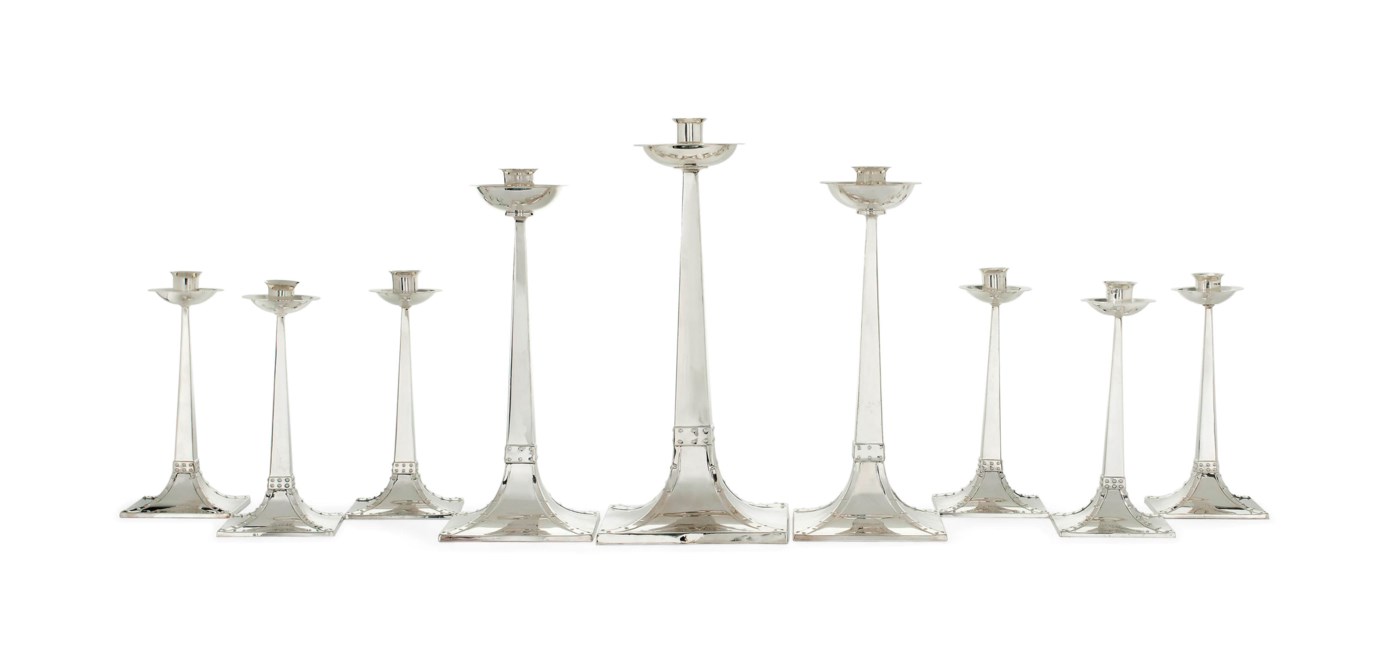 A GRADUATED AND MATCHED SET OF NINE ARTS & CRAFTS SILVER CANDLESTICKS