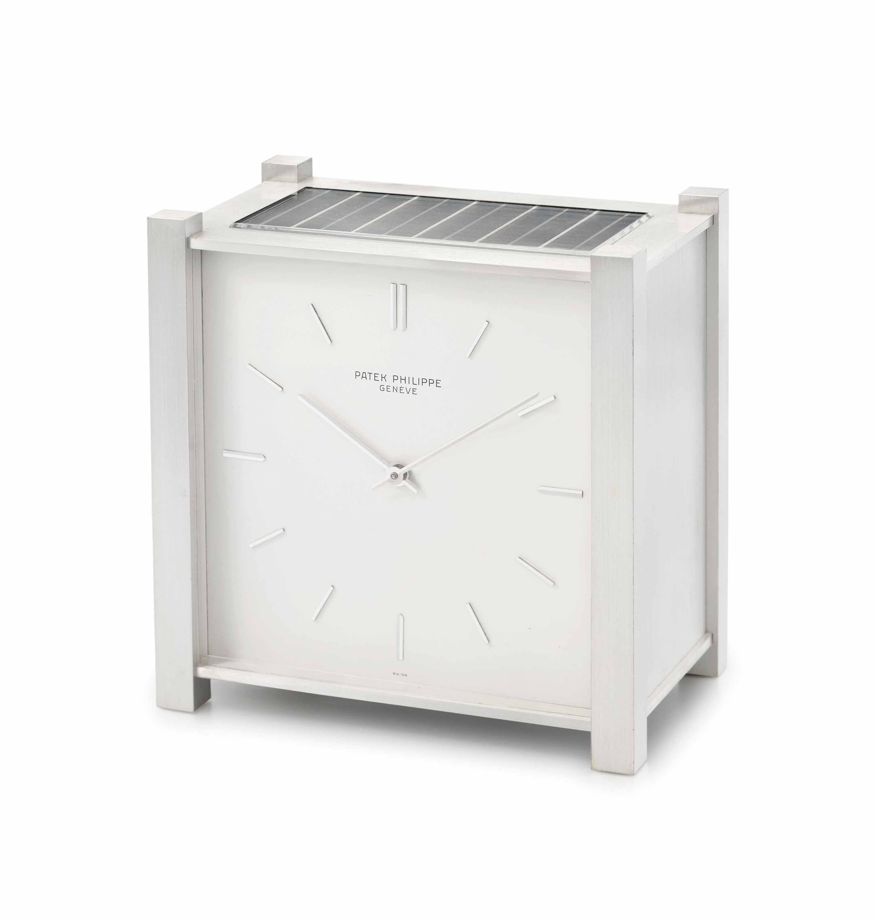 Patek Philippe. A fine rhodiumplated brass square solarpowered desk