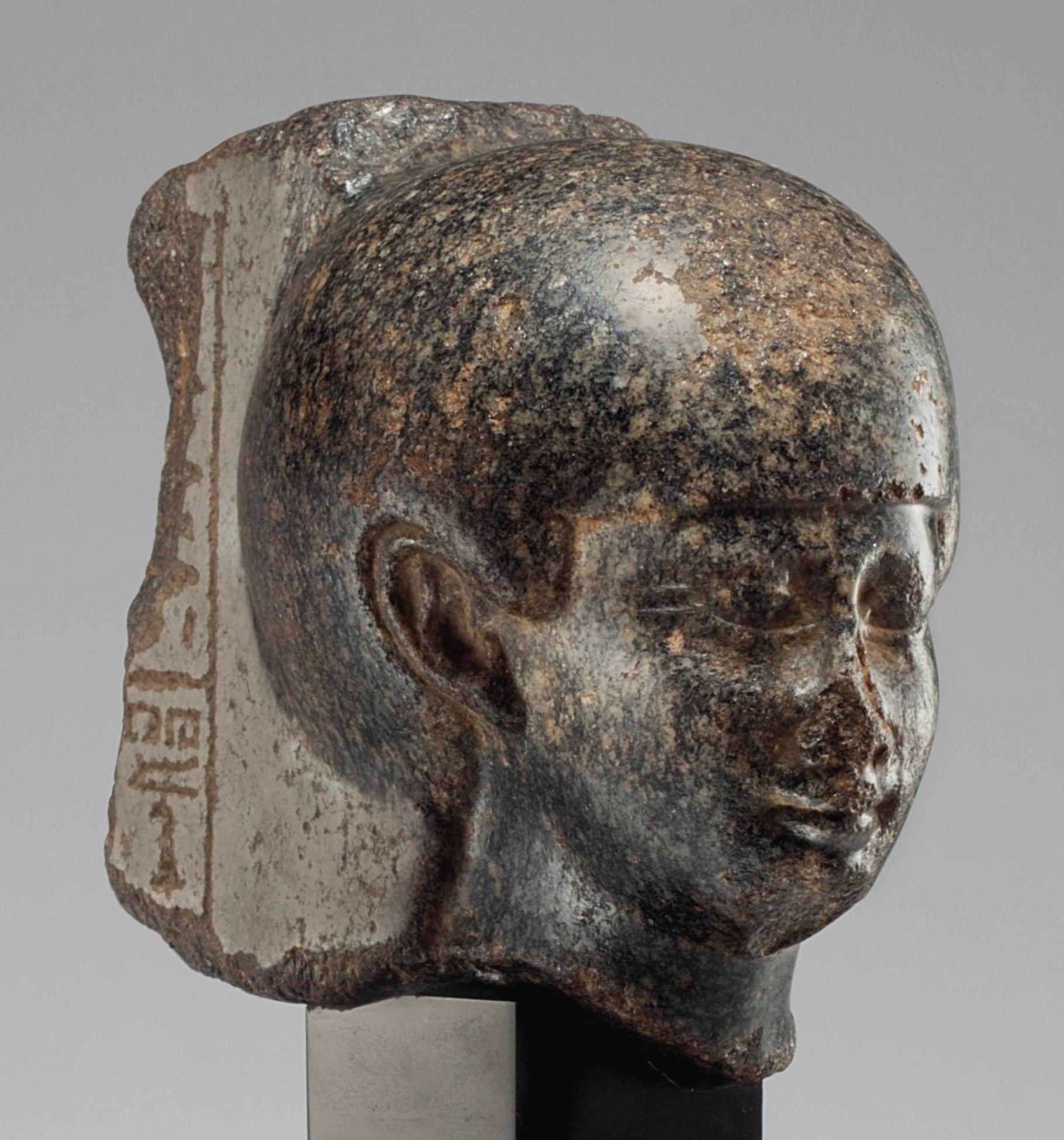 AN EGYPTIAN GRANITE HEAD OF A WOMAN