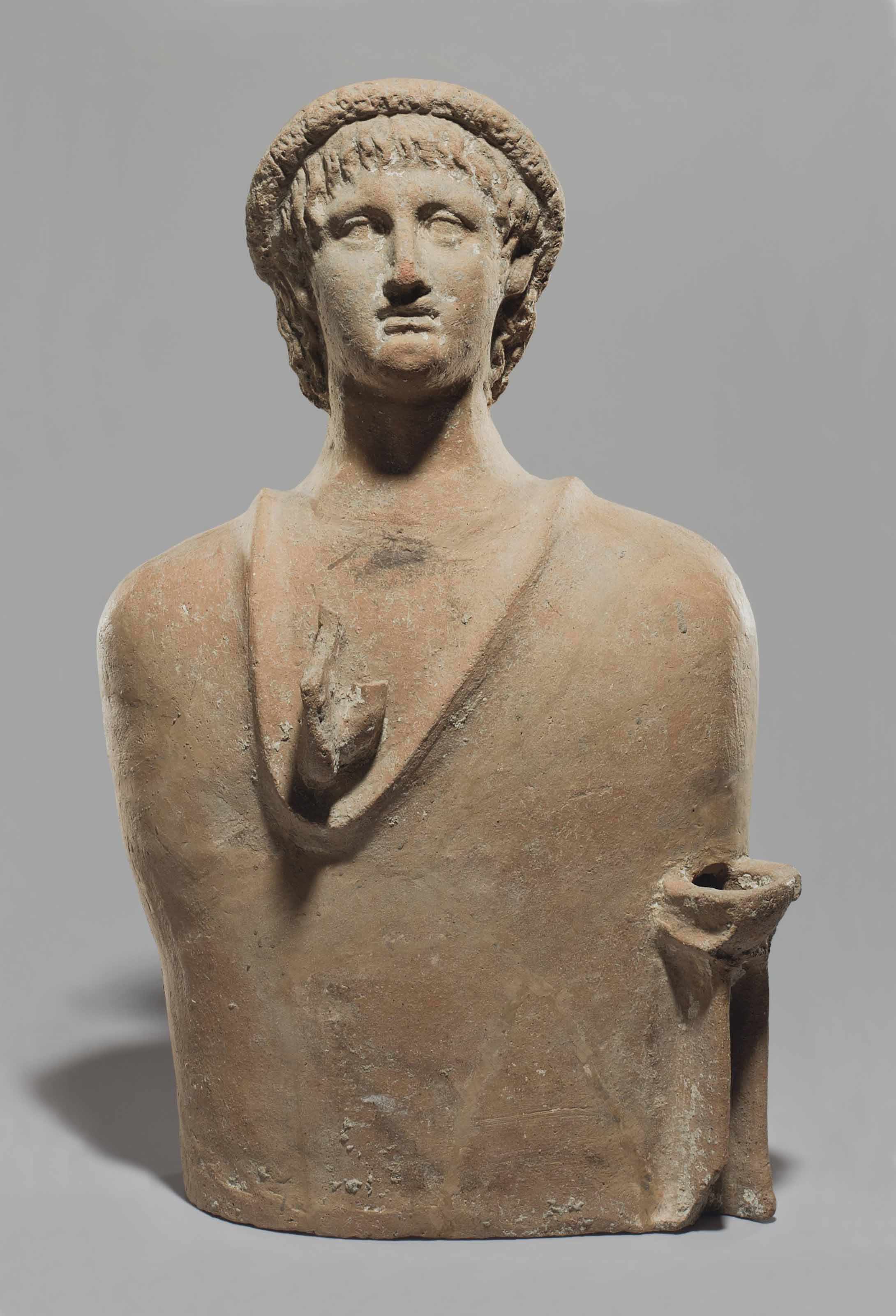AN ETRUSCAN TERRACOTTA VOTIVE BUST OF A MAN , CIRCA 3RD CENTURY B.C