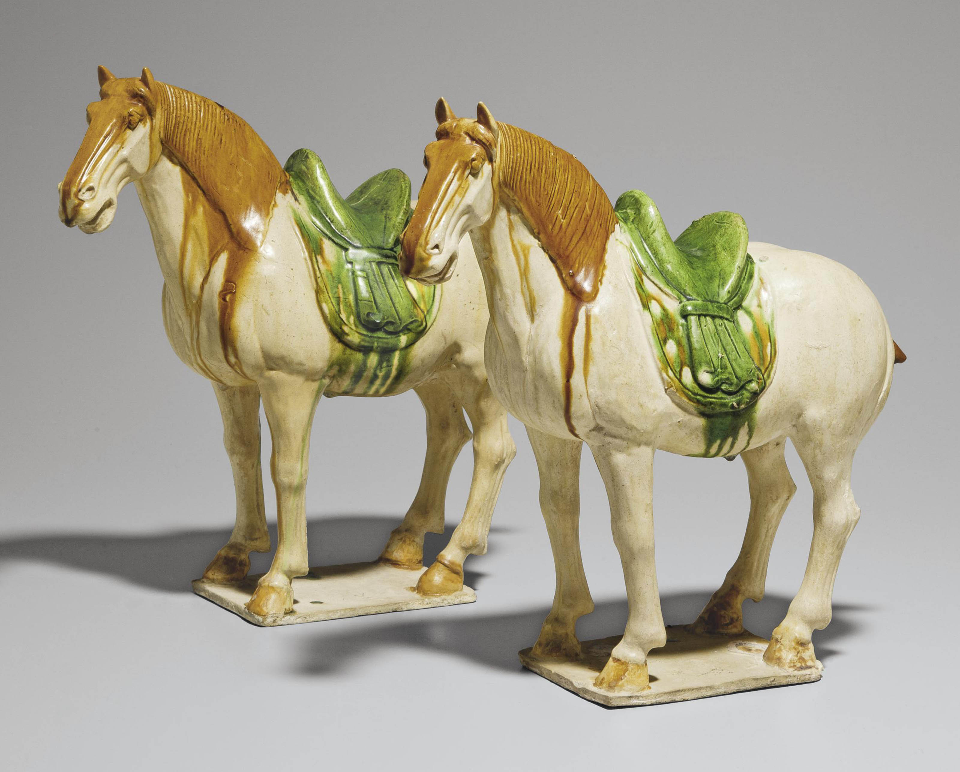 A PAIR OF SANCAI GLAZED POTTERY FIGURES OF HORSES , TANG DYNASTY (618