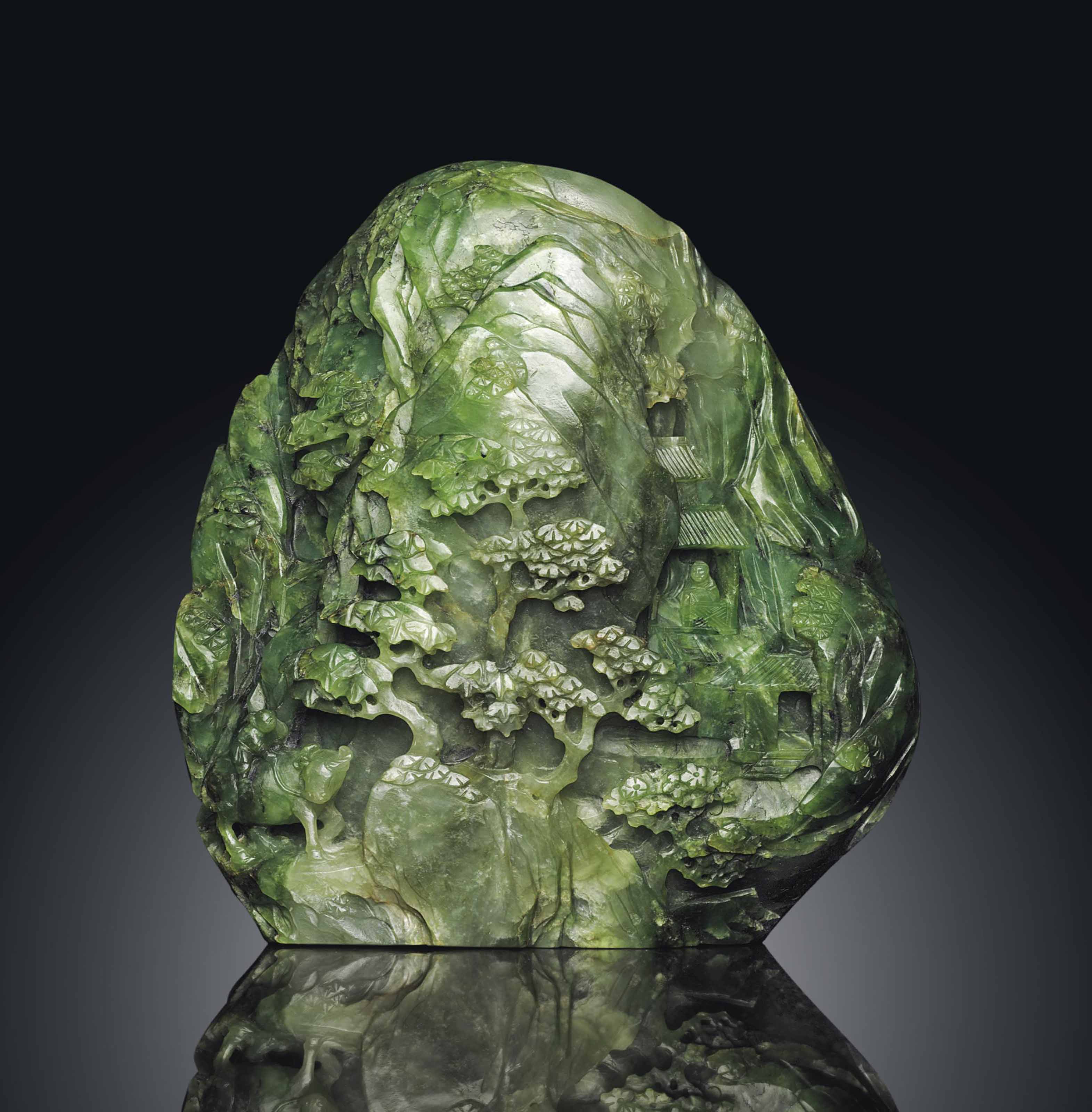 A FINELY CARVED MOTTLED SPINACHGREEN JADE BOULDER