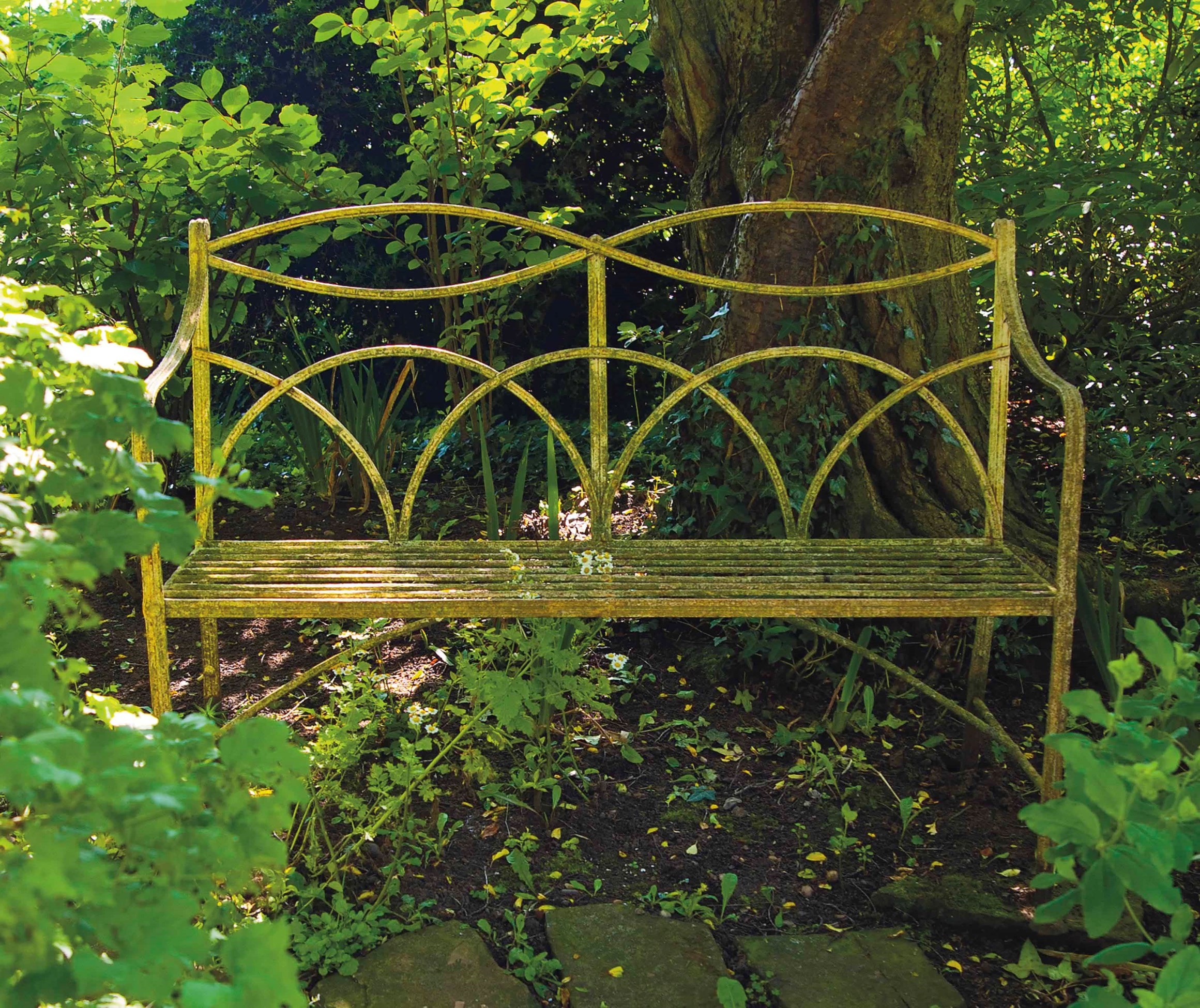 A PAINTED WROUGHTIRON GARDEN BENCH