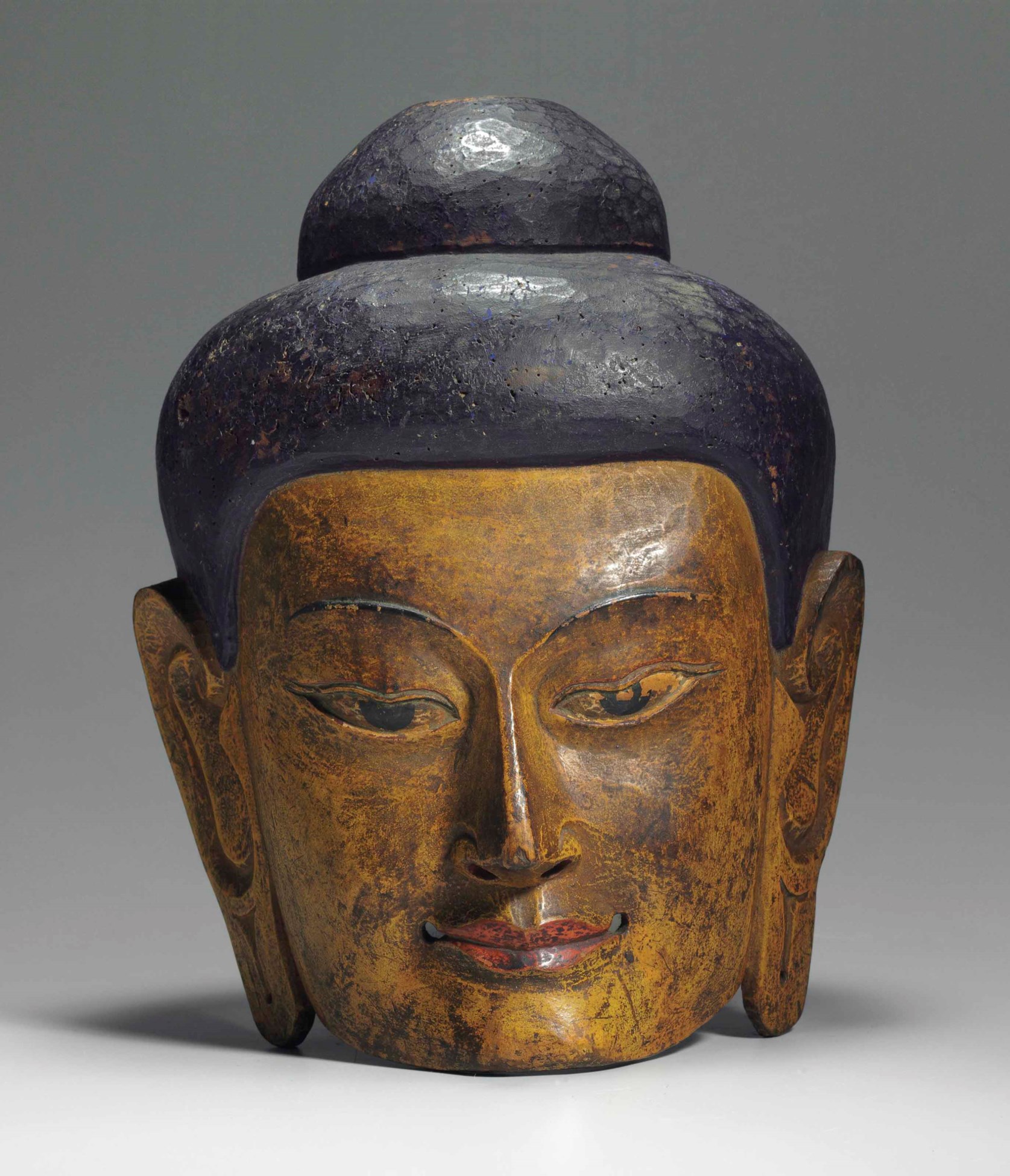 A painted wooden mask of Buddha