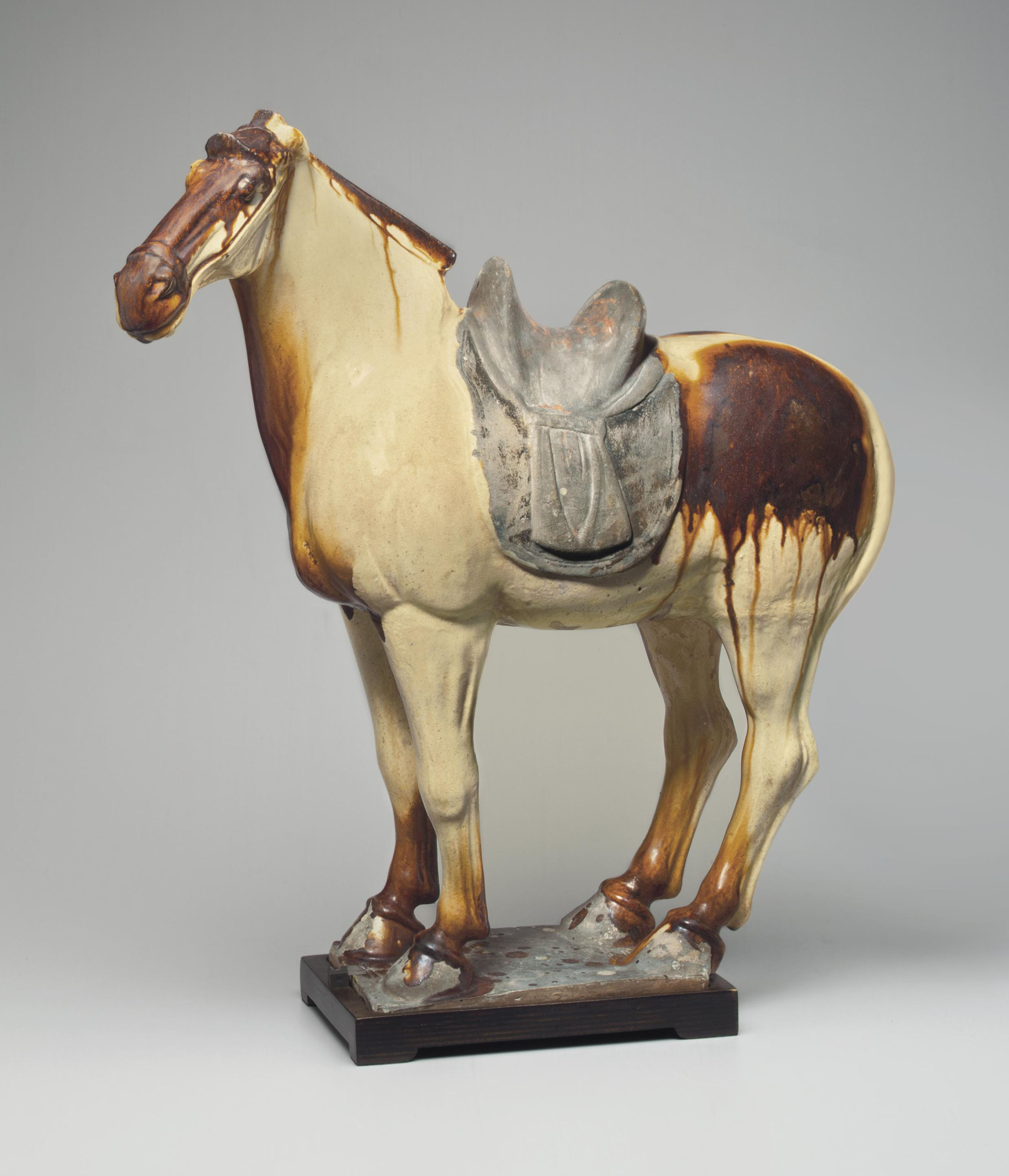 A CHESTNUT AND STRAWGLAZED POTTERY FIGURE OF A HORSE , TANG DYNASTY