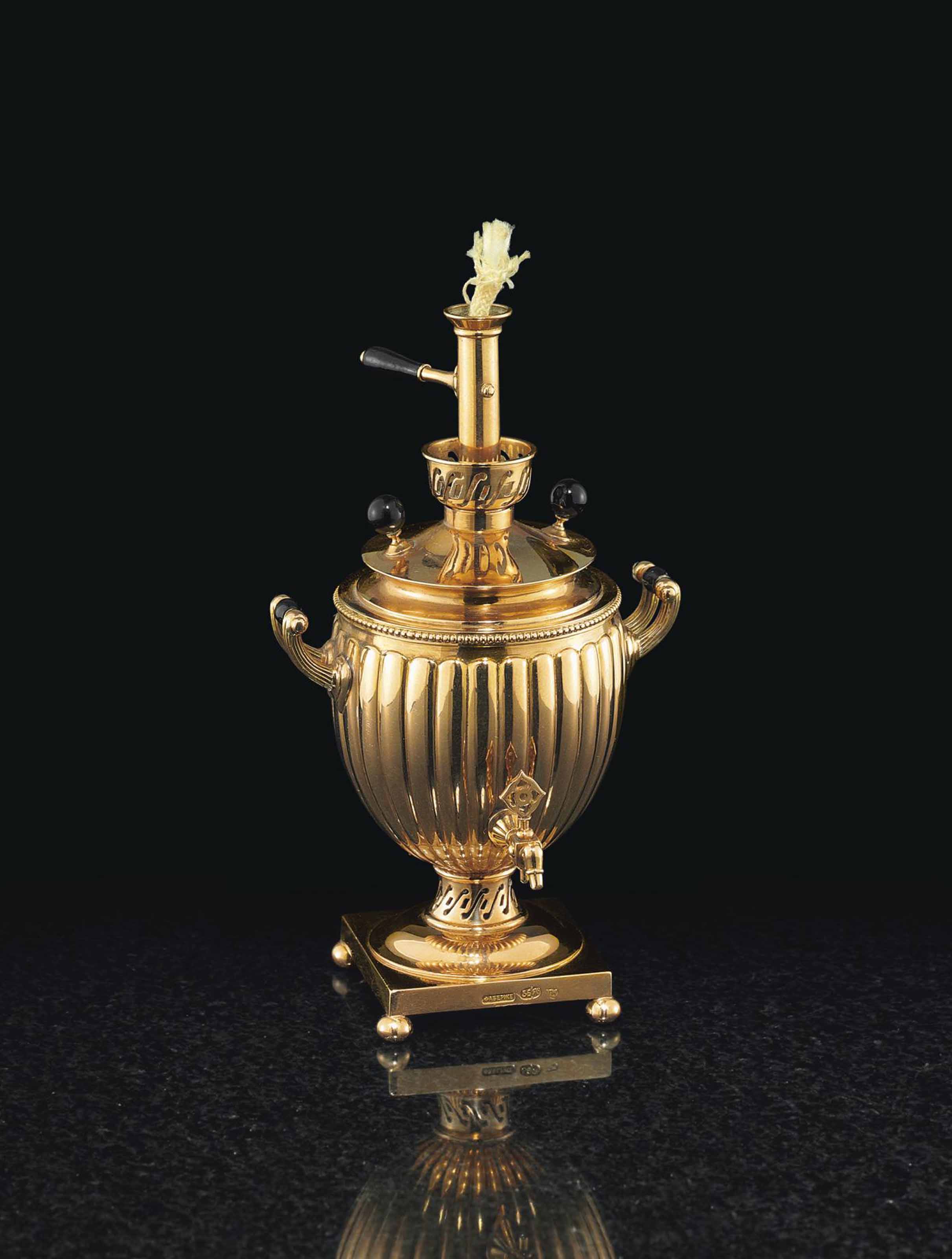 A GOLD TABLE LIGHTER IN THE FORM OF A MINIATURE SAMOVAR , MARKED FABERGÉ,  WITH THE WORKMASTER'S MARK OF MICHAEL PERCHIN, ST. PETERSBURG, CIRCA 1890 |  Christie's