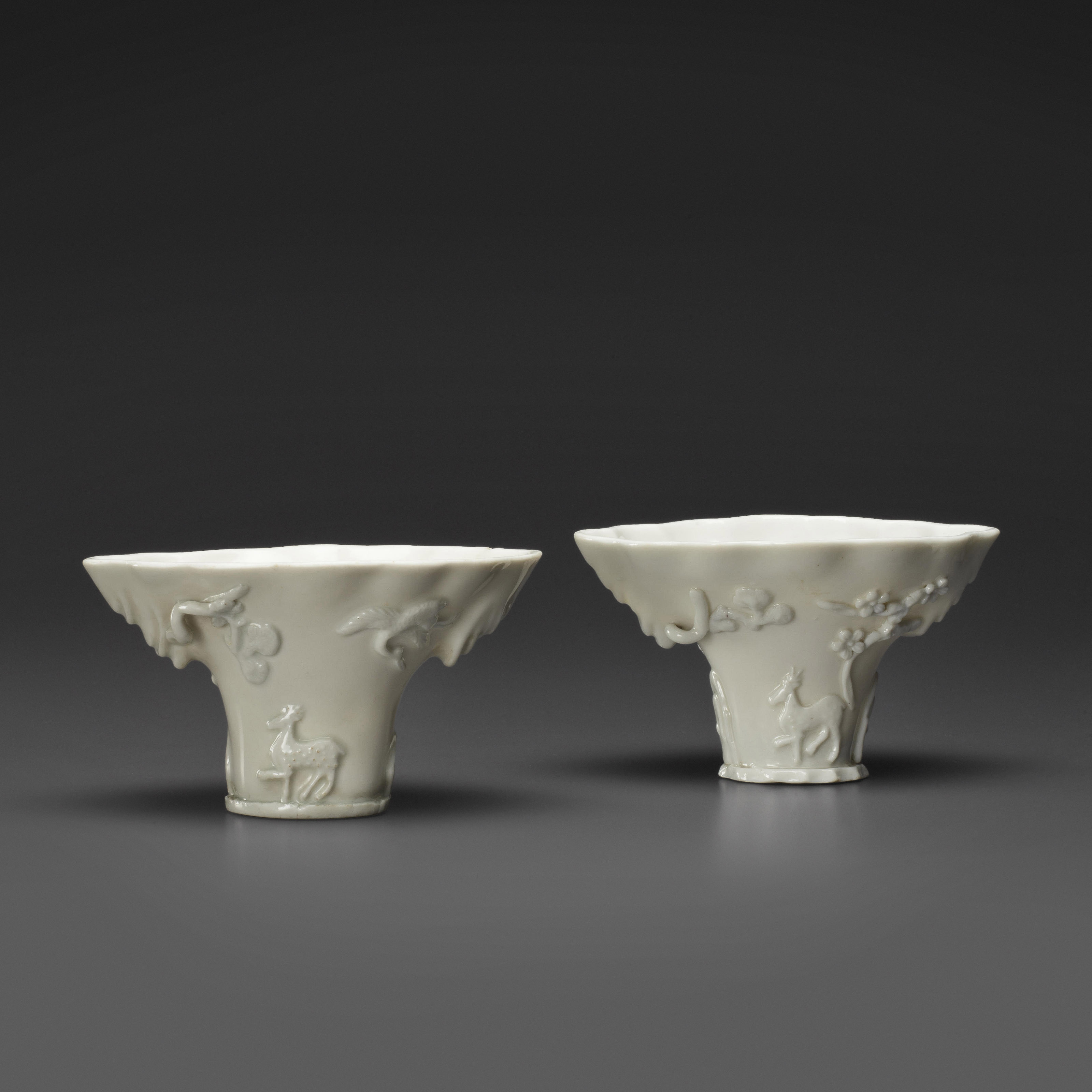 TWO DEHUA RHINOCEROS HORN-FORM LIBATION CUPS, 17TH/18TH CENTURY