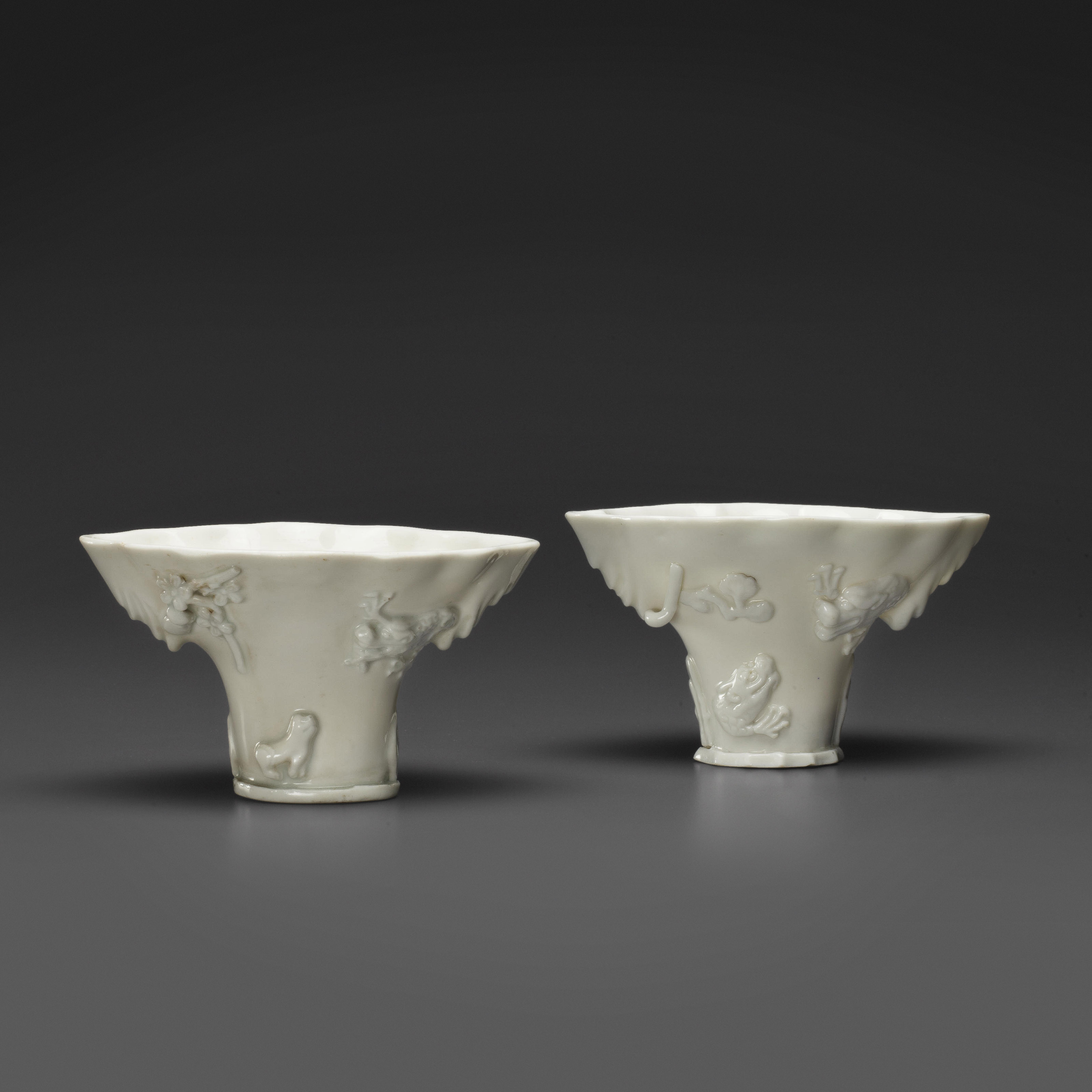 TWO DEHUA RHINOCEROS HORN-FORM LIBATION CUPS, 17TH/18TH CENTURY