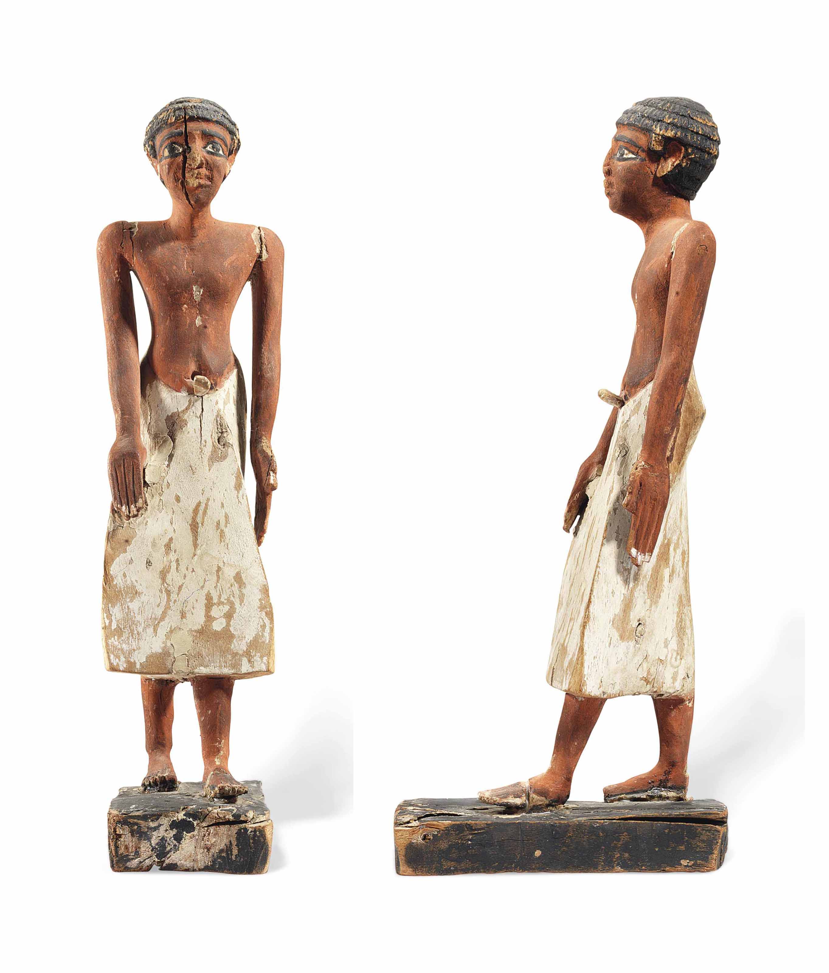 AN EGYPTIAN PAINTED WOOD FIGURE OF AN OFFICIAL
