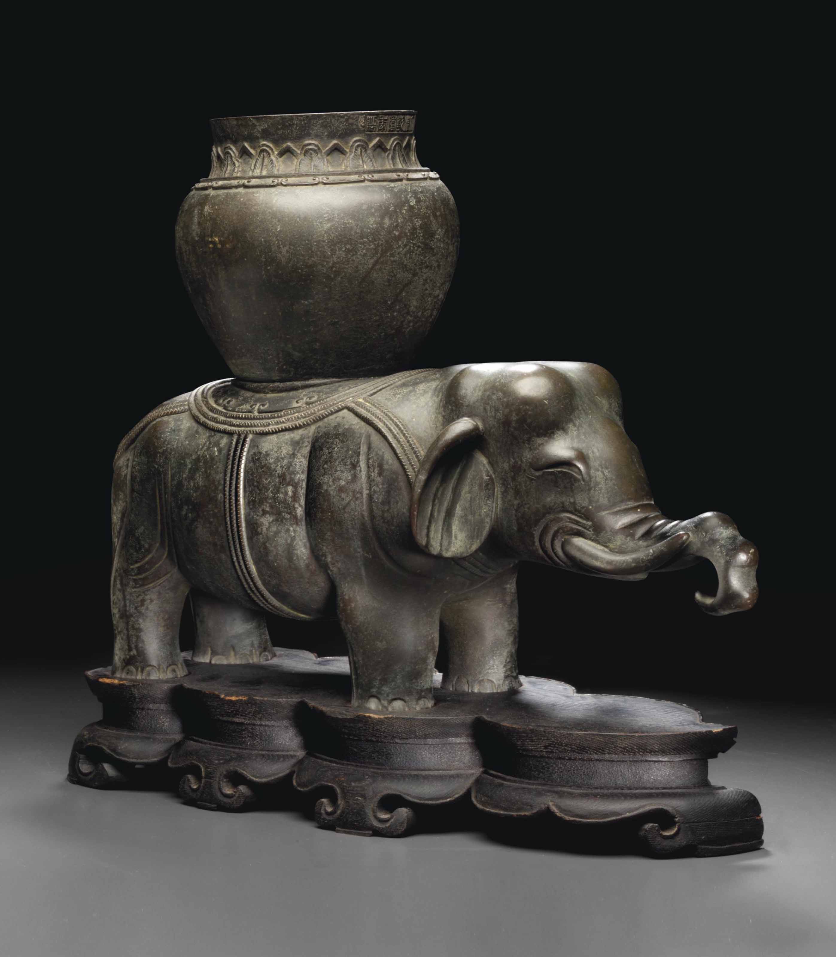 A RARE BRONZE FIGURE OF AN ELEPHANT SUPPORTING A VASE QIANLONG SIX CHARACTER MARK CAST IN A 