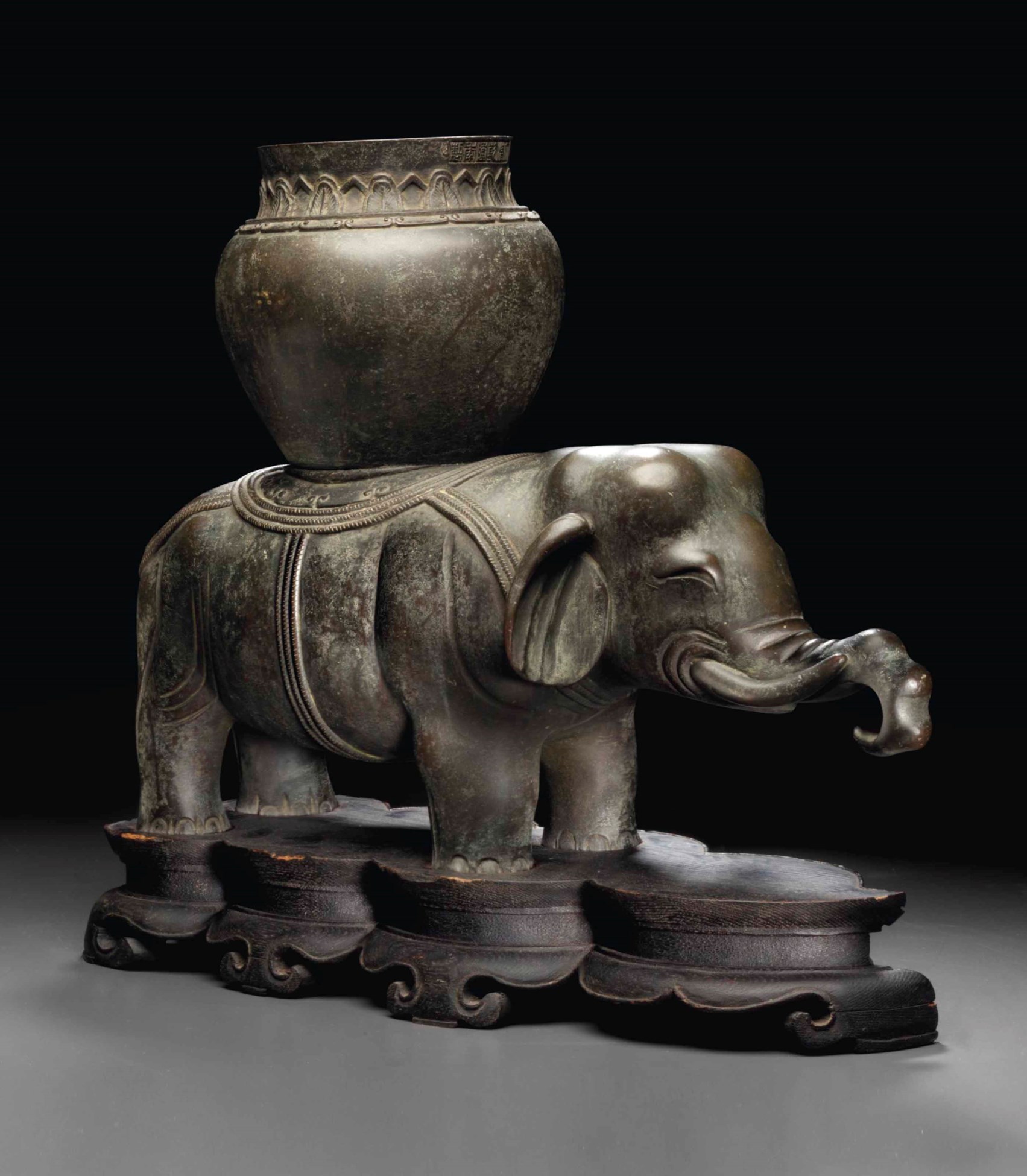 A RARE BRONZE FIGURE OF AN ELEPHANT SUPPORTING A VASE