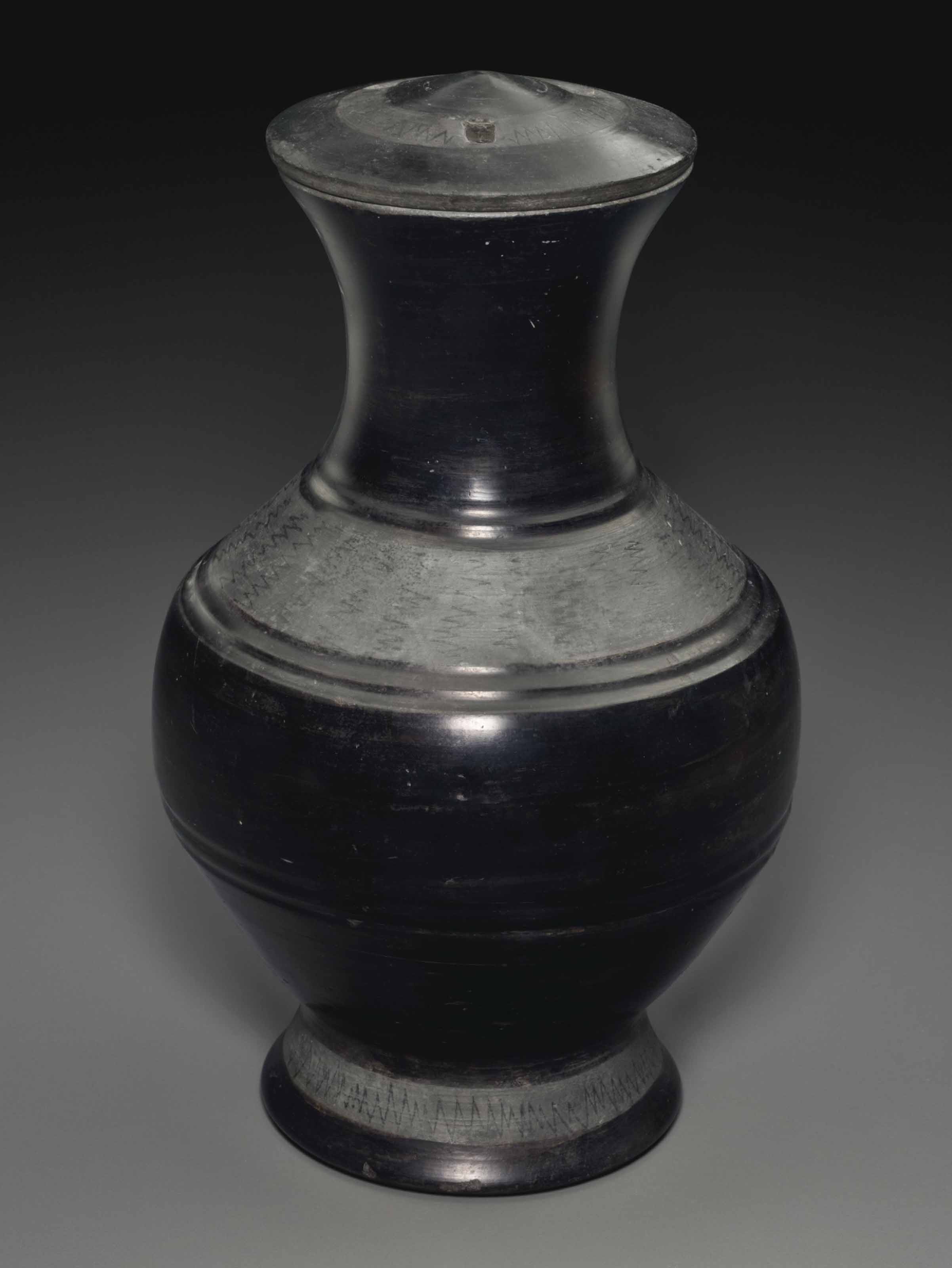 A BURNISHED BLACK POTTERY JAR AND COVER, HU , WARRING STATES PERIOD
