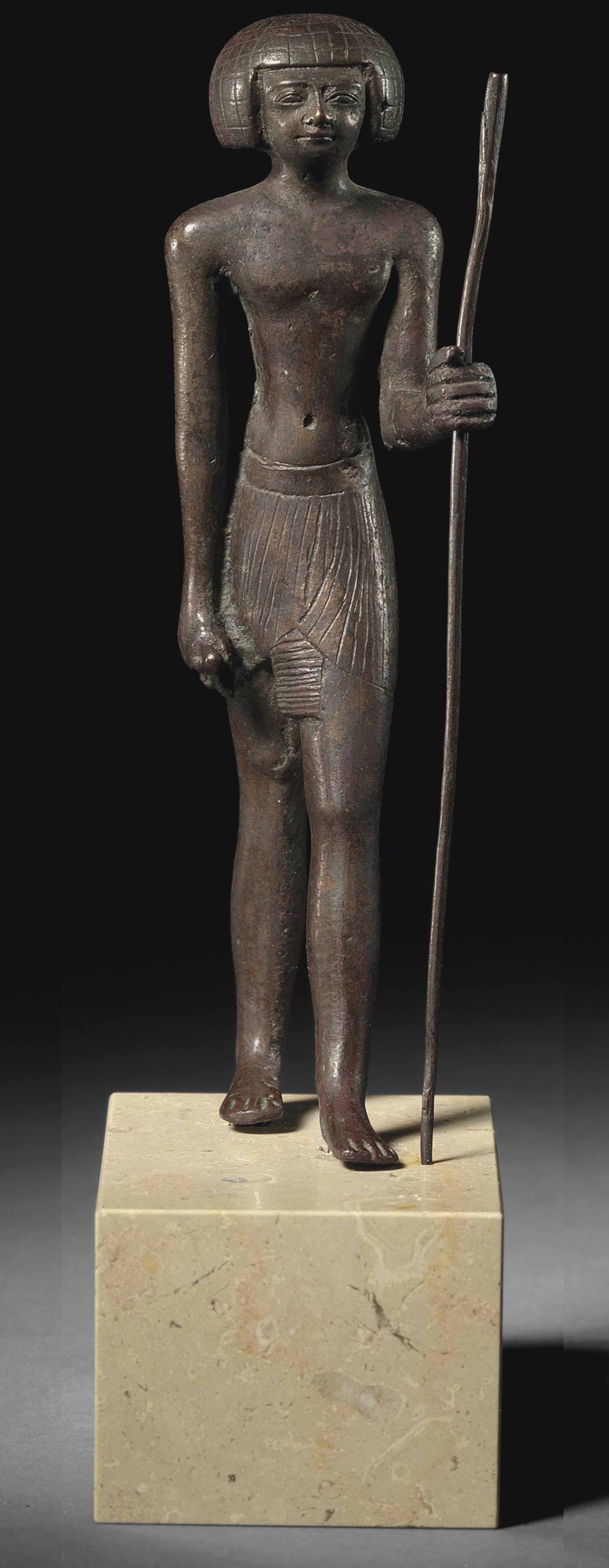 AN EGYPTIAN COPPER ALLOY FIGURE OF A MAN , NEW KINGDOM, EARLY 18TH